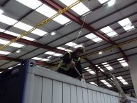 Warehouse crane hook being attached to a shipping container inside a Canadian industrial facility