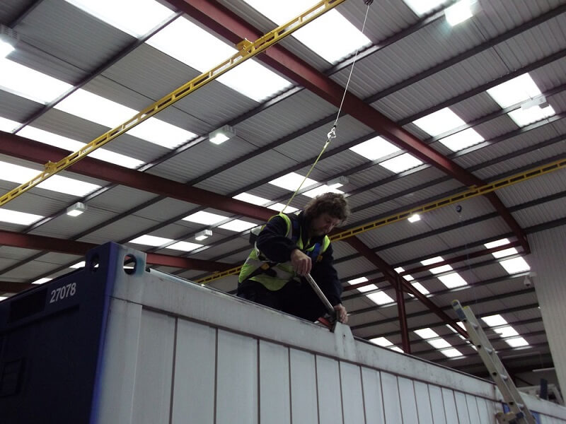 attaching a warehouse crane to a shipping container.