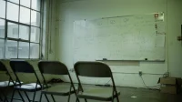 Canadian startup whiteboard with a hand-drawn IT roadmap in blue marker beside a row of empty folding chairs